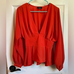 Reddish-orange blouse. Medium